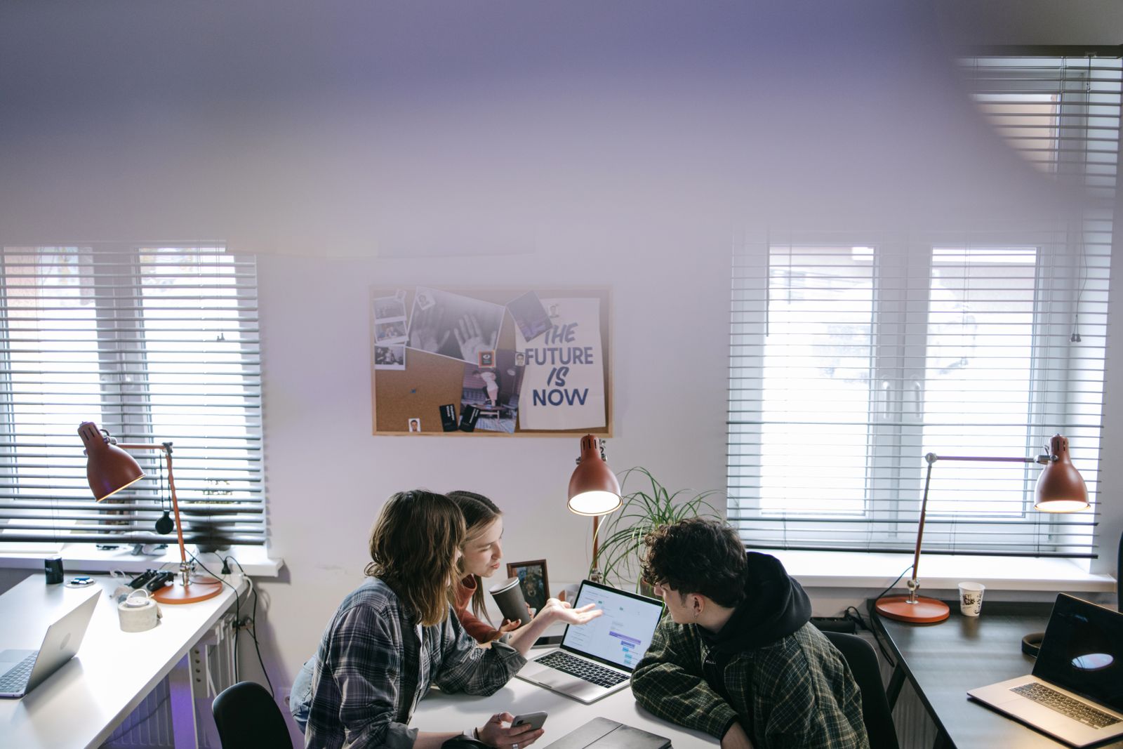 A team meeting around a table in an office, representing shared employee ownership